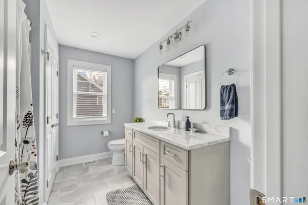 a bathroom with a double vanity sink a toilet and a mirror
