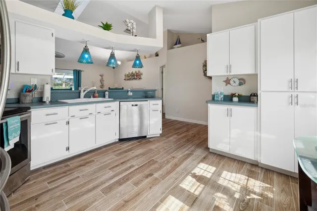a kitchen with white cabinets and refrigerator