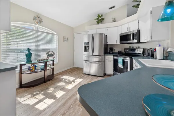 a kitchen with stainless steel appliances granite countertop a refrigerator stove microwave and sink
