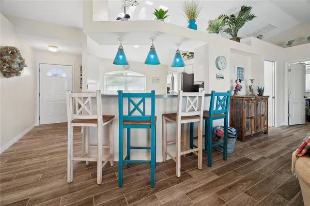 a view of a dining room with wooden floor and furniture