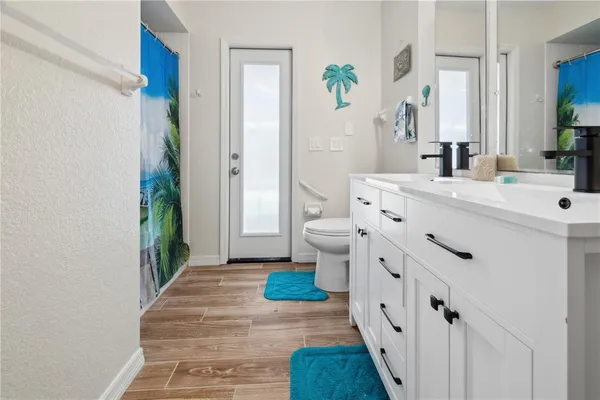 a bathroom with a sink a toilet and shower