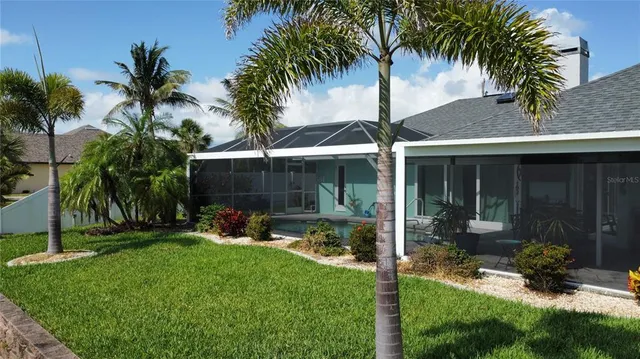 front view of a house with a yard and potted plants