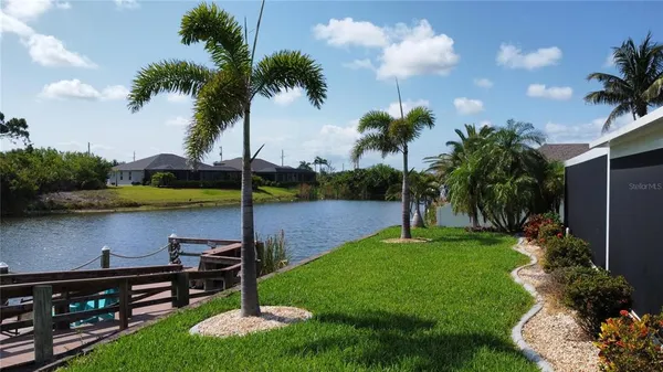a view of a garden with a bench and lake view