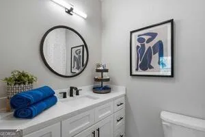 a bathroom with a toilet a sink and a mirror