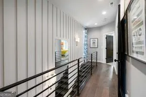 a view of a hallway with wooden floor and staircase