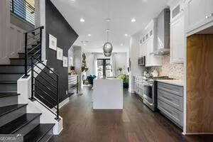 a large kitchen with stainless steel appliances lots of counter space and windows