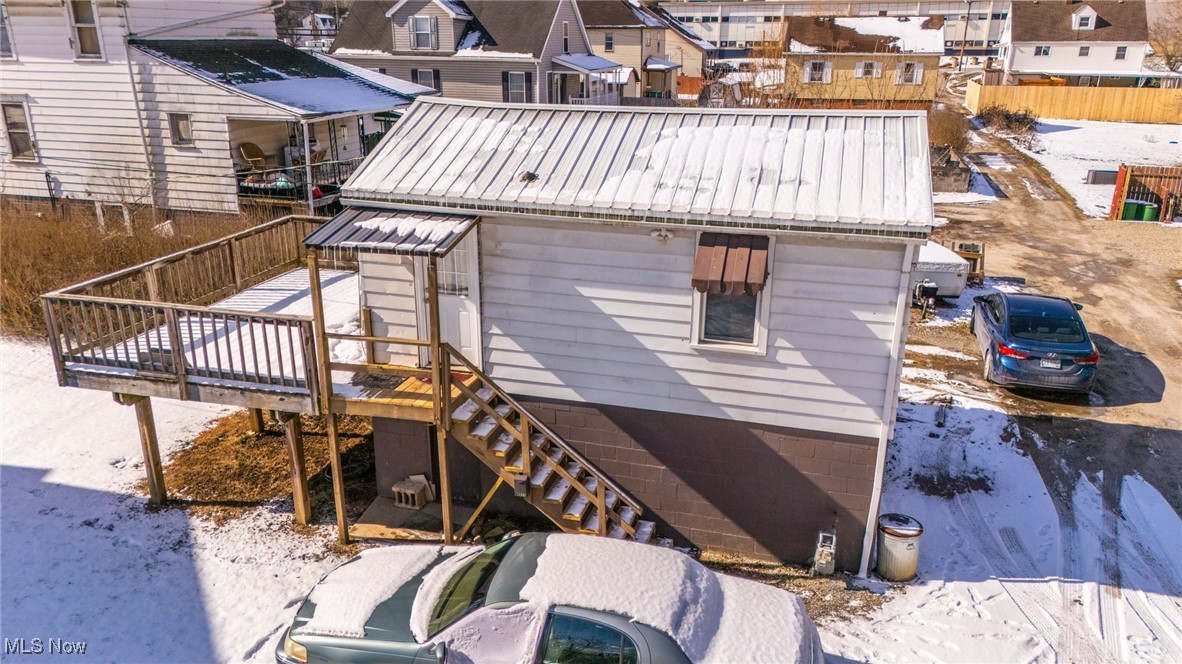 55577 National Road Bridgeport, OH 43912 - Photo 10 of 17 Snow covered property with stairs, metal roof, a wooden deck, and a residential view