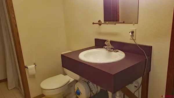 a bathroom with a toilet a sink and mirror