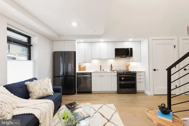 a view of a hallway with wooden floor and a living room