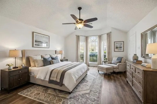 a bedroom with a large bed and a chandelier