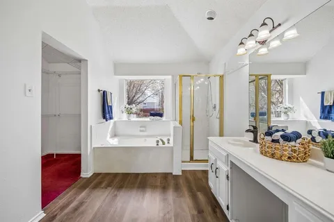 a large spacious bathroom with a double vanity sink a mirror and a bathtub