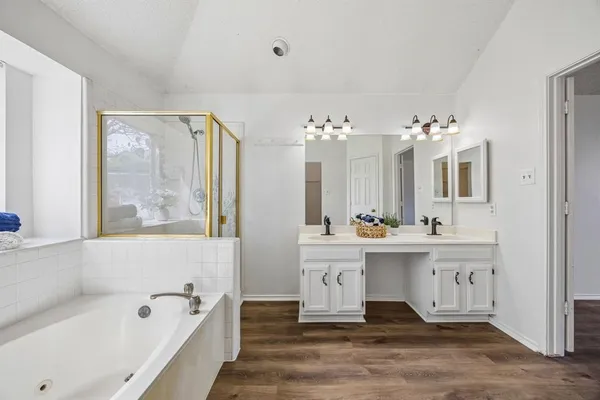a spacious bathroom with a tub sink and mirror