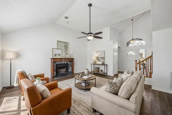 a living room with furniture a fireplace and a chandelier