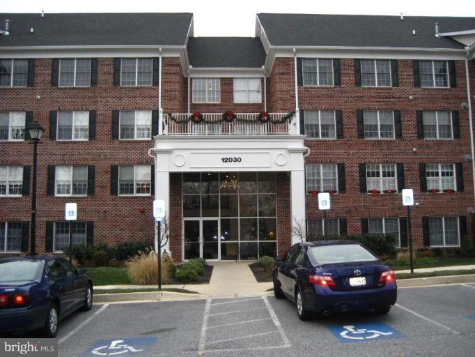 12030 Tralee Road, Unit 401 Lutherville-Timonium, MD 21093 - Photo 1 of 1 a car parked in front of a brick building
