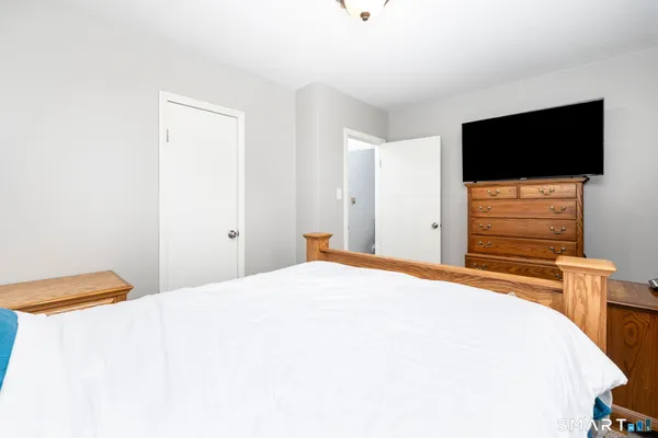 a bedroom with a bed and a flat screen tv