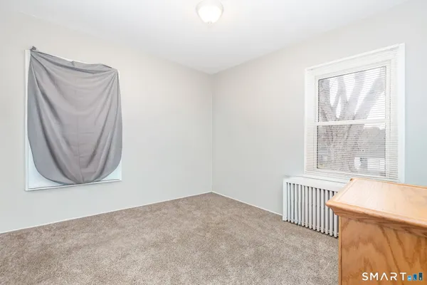 an empty room with a window and a mirror