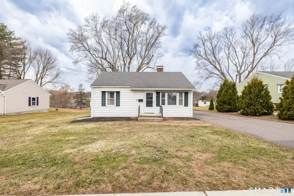 a front view of house with yard and trees around