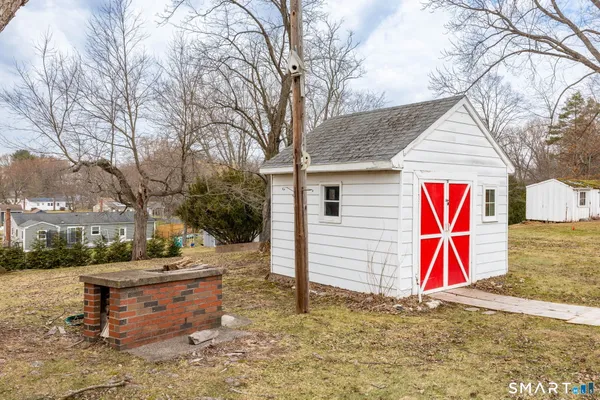 a backyard of a house with barbeque oven and outdoor seating