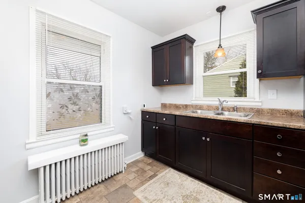 a bathroom with a granite countertop sink a large mirror and a window
