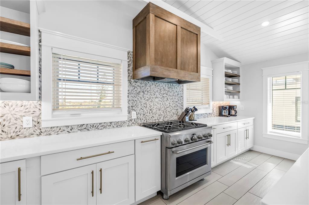 316 Beach Road Sarasota, FL 34242 - Photo 78 of 98 a kitchen with stainless steel appliances granite countertop white cabinets and a stove top oven