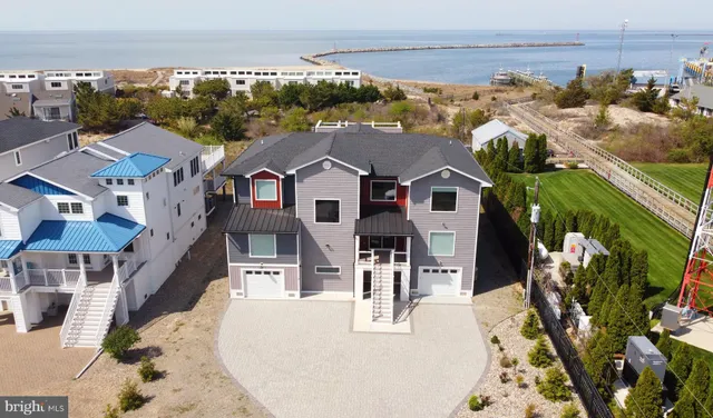 an aerial view of residential houses with outdoor space and ocean view