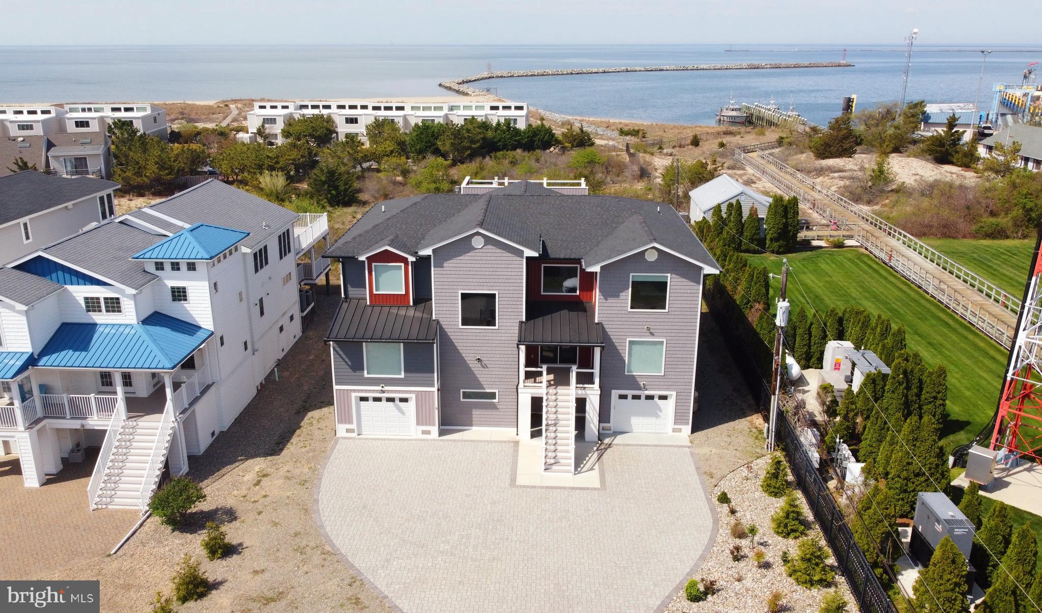 an aerial view of residential houses with outdoor space and ocean view