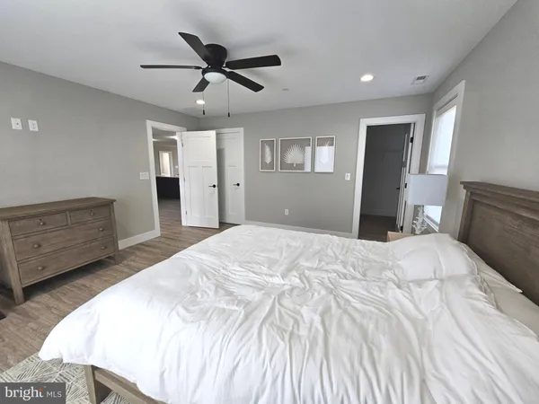 a spacious bedroom with a bed and a dresser