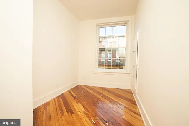 a view of a room with wooden floor and a window