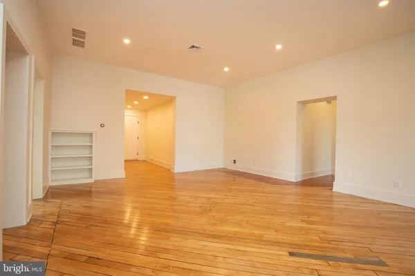 a view of empty room with wooden floor