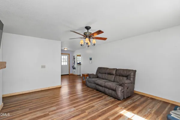 a living room with couches and a ceiling fan with wooden floor