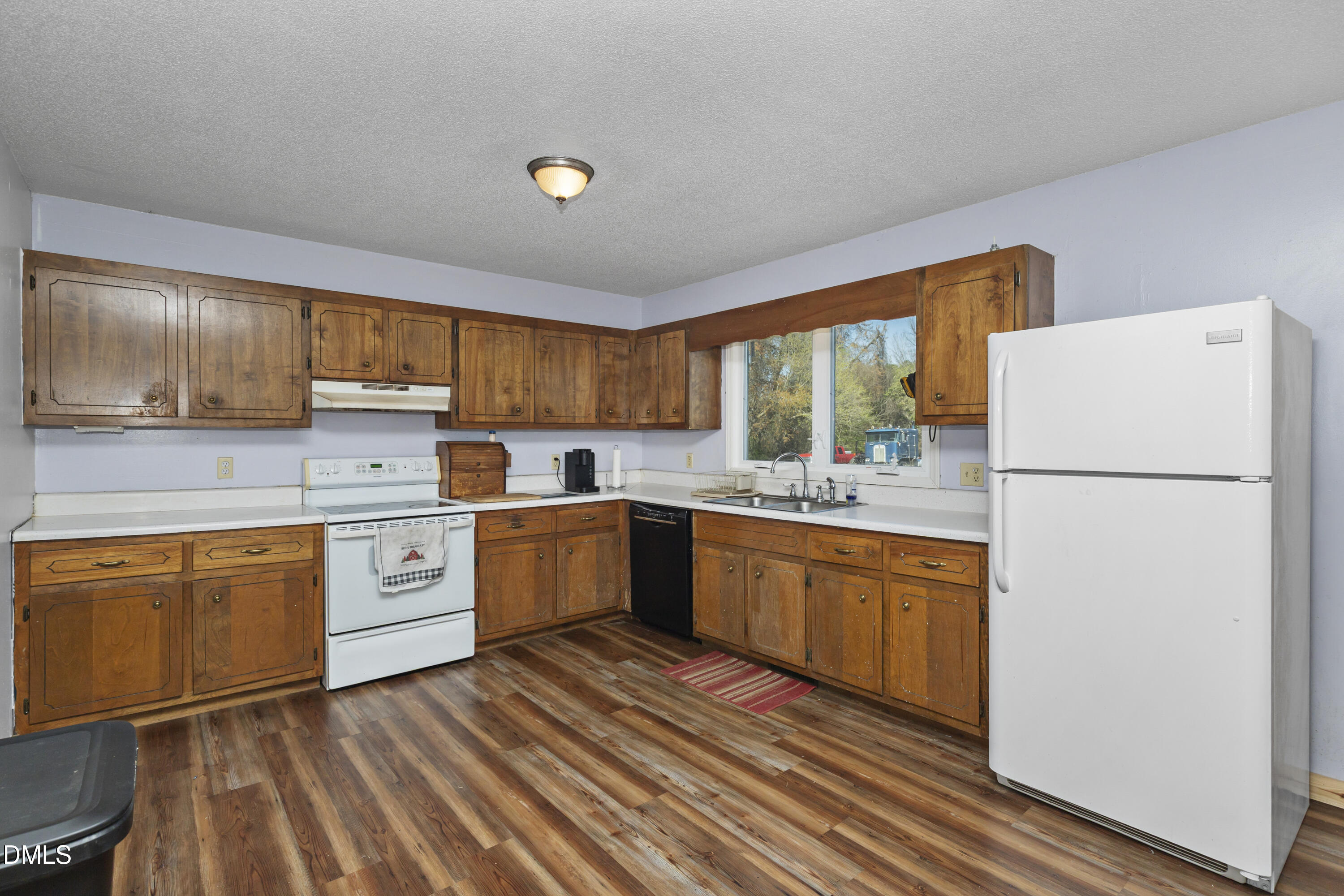 288 Baileys Crossroads Road Benson, NC 27504 - Photo 8 of 26 a kitchen with sink a refrigerator and white cabinets