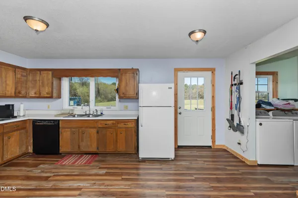 a kitchen with stainless steel appliances granite countertop a refrigerator a stove top oven and a sink with granite countertops