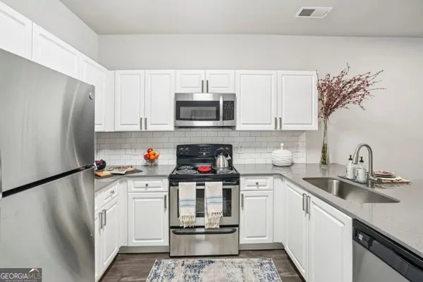 a kitchen with stainless steel appliances a stove refrigerator sink and cabinets