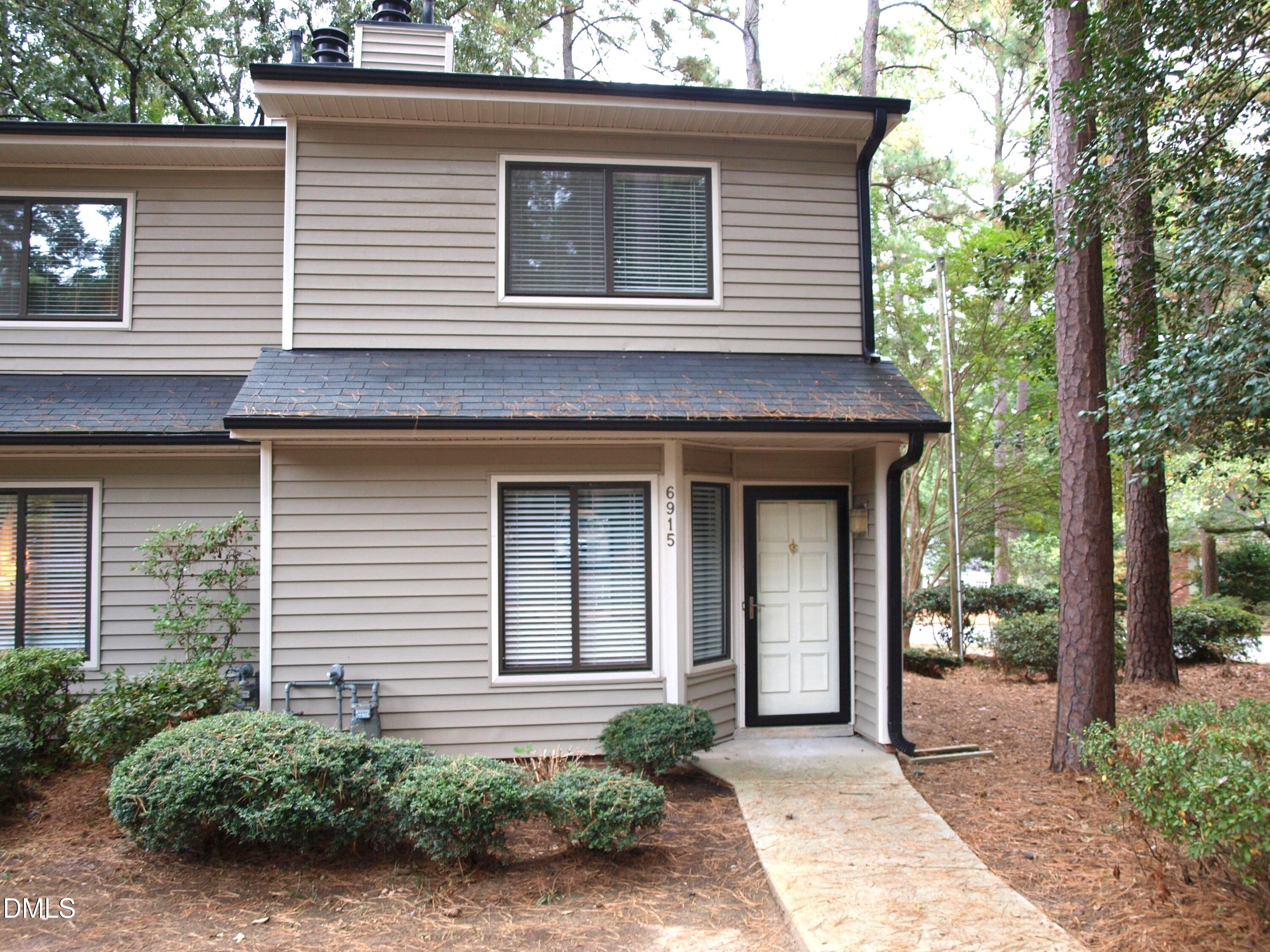 6915 Staghorn Lane Raleigh, NC 27615 - Photo 1 of 12 a front view of a house with garden