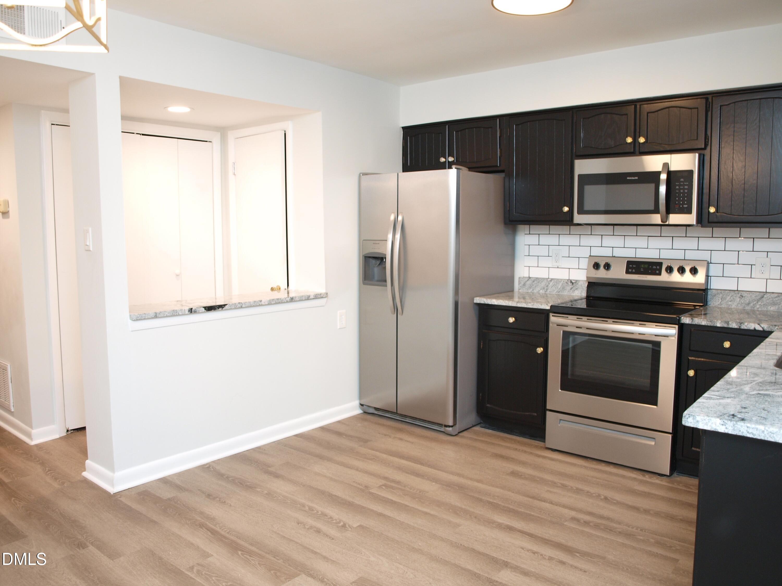6915 Staghorn Lane Raleigh, NC 27615 - Photo 3 of 12 a kitchen with stainless steel appliances a refrigerator stove and microwave