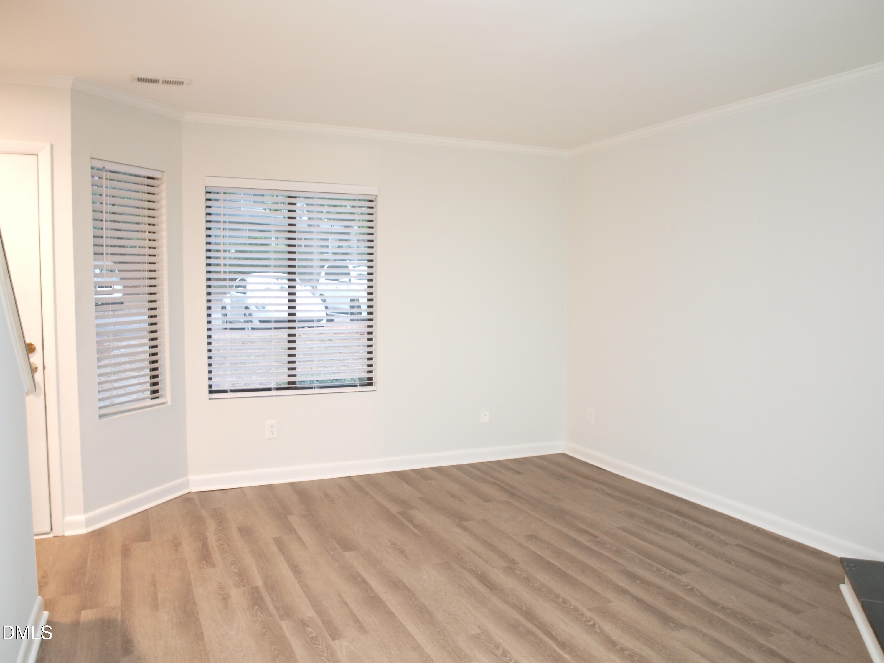 6915 Staghorn Lane Raleigh, NC 27615 - Photo 5 of 12 an empty room with wooden floor and windows