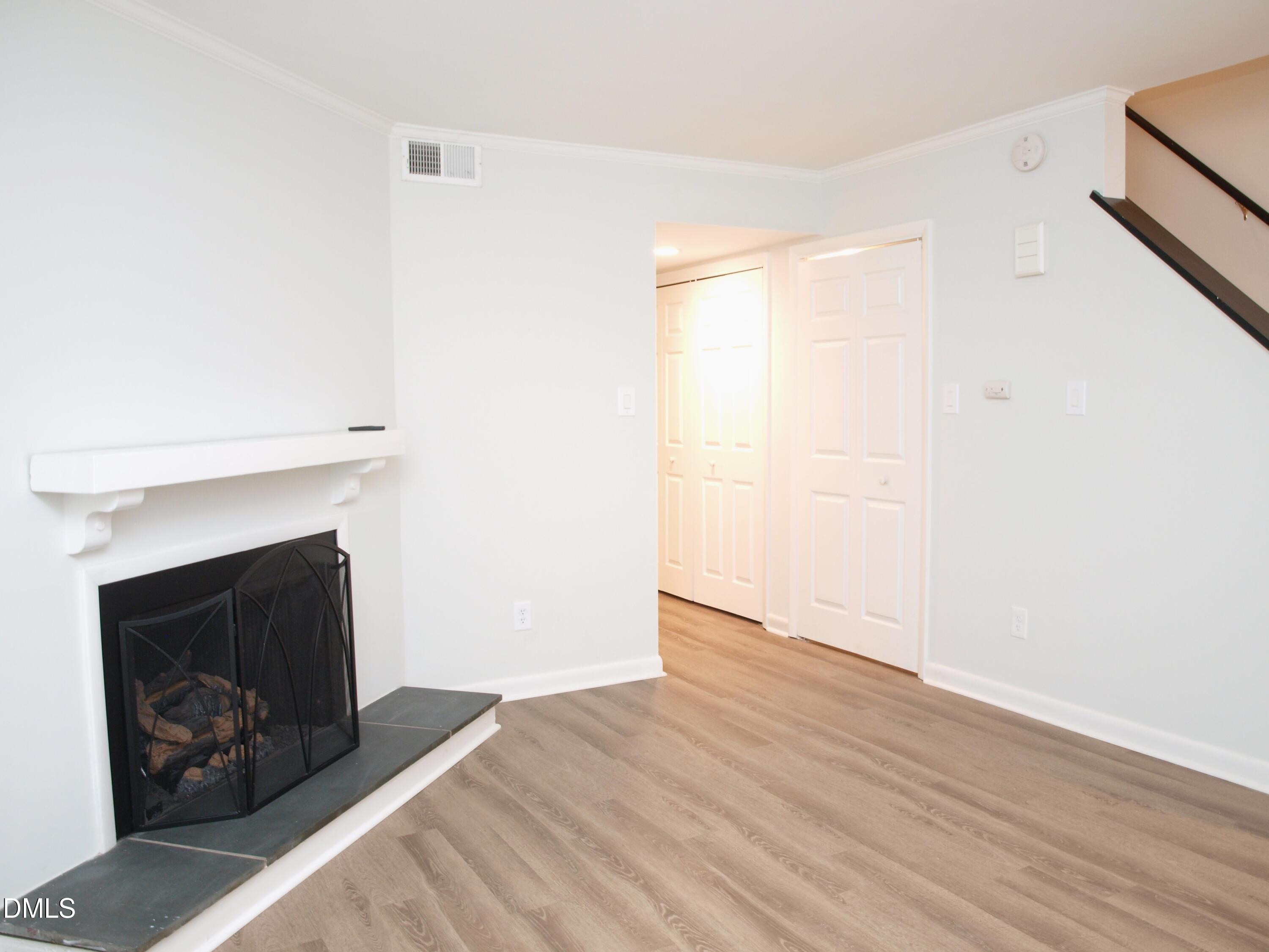 6915 Staghorn Lane Raleigh, NC 27615 - Photo 6 of 12 a view of an empty room with wooden floor and a fireplace