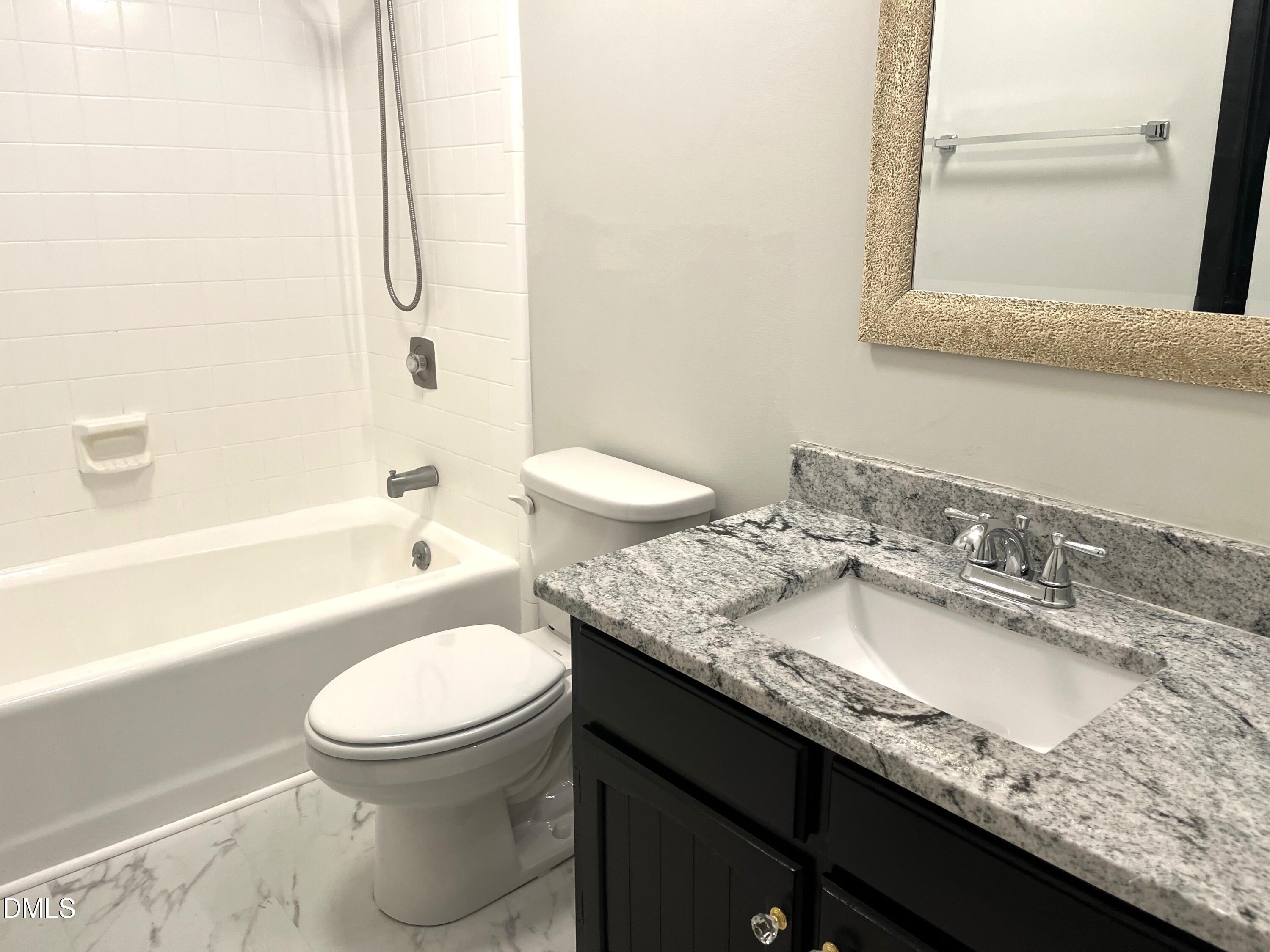 6915 Staghorn Lane Raleigh, NC 27615 - Photo 8 of 12 a bathroom with a granite countertop sink toilet and shower