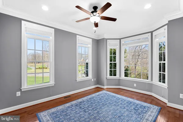 a large dining hall with stainless steel appliances kitchen island granite countertop a table chairs in it and a large window