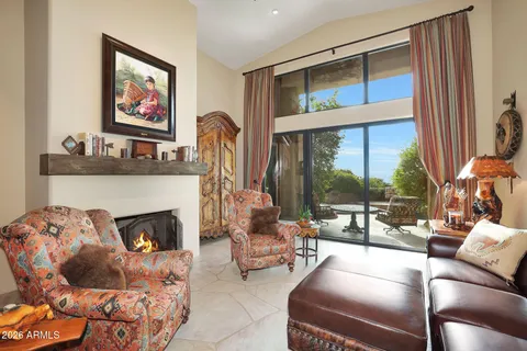 a living room with furniture fireplace and a large window