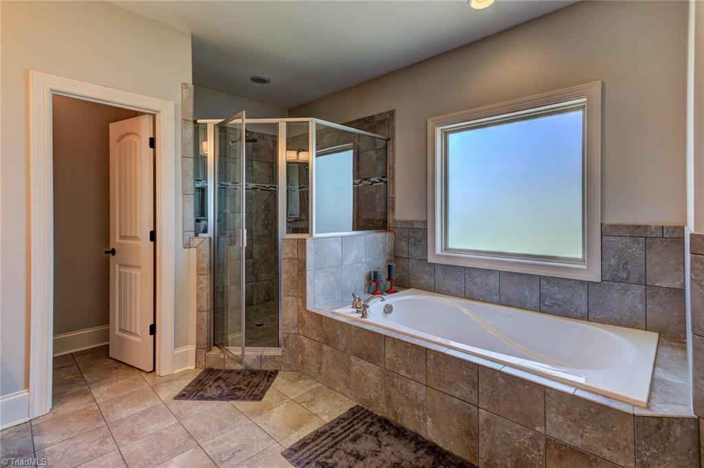 8889 Rymack Drive Oak Ridge, NC 27310 - Photo 16 of 30 Private master bathroom with extra long soaking tub and walk in shower