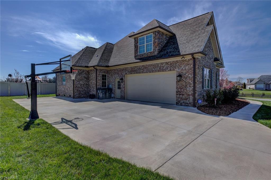8889 Rymack Drive Oak Ridge, NC 27310 - Photo 28 of 30 Two car garage features ultra quiet garage door plus an additional parking pad.