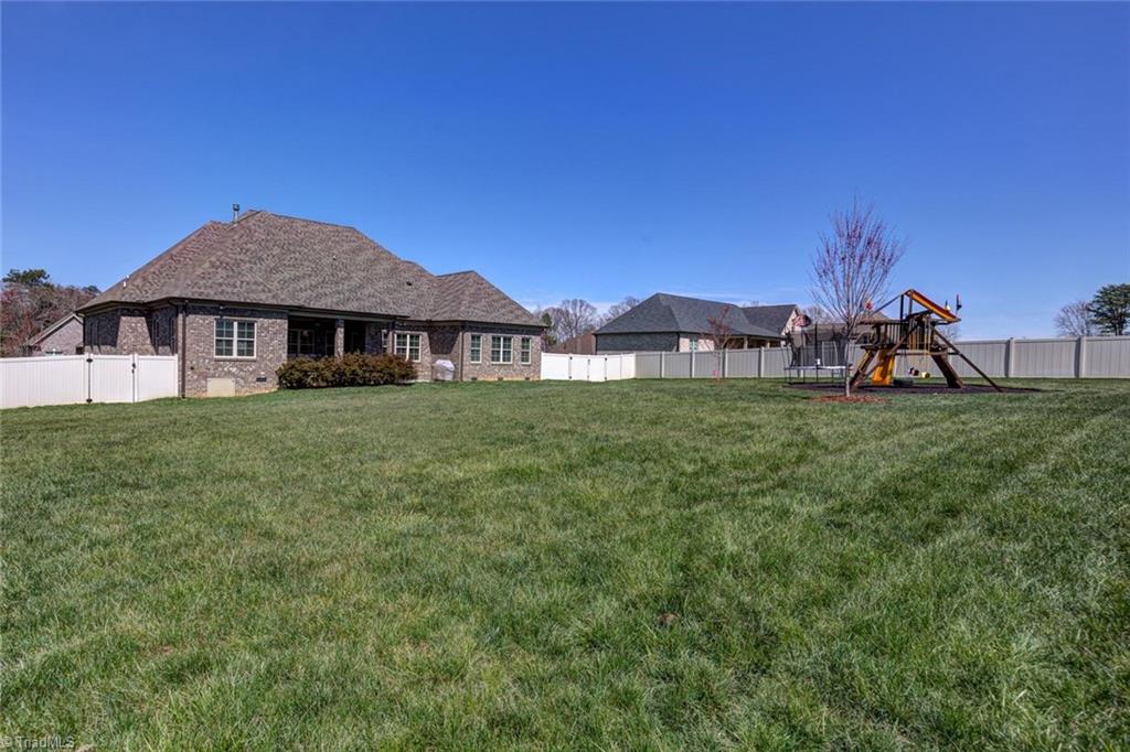 8889 Rymack Drive Oak Ridge, NC 27310 - Photo 30 of 30 A level backyard is surrounded by a privacy fence.