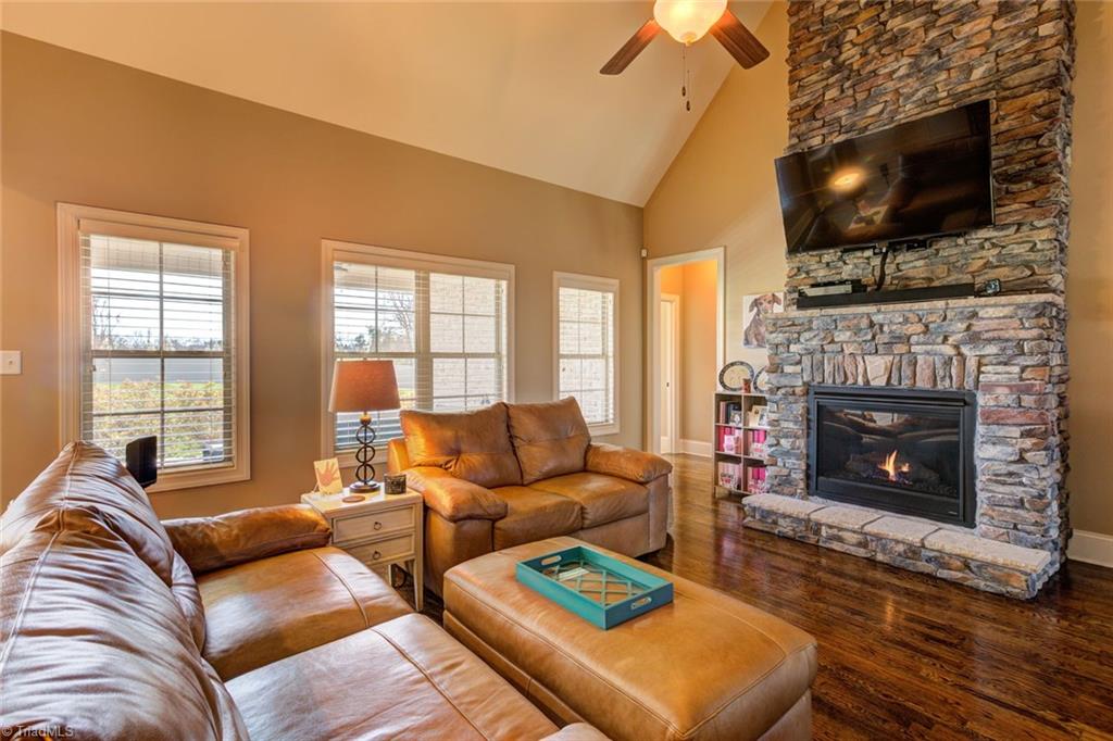 8889 Rymack Drive Oak Ridge, NC 27310 - Photo 6 of 30 Stacked stone gas fireplace with a raised hearth.