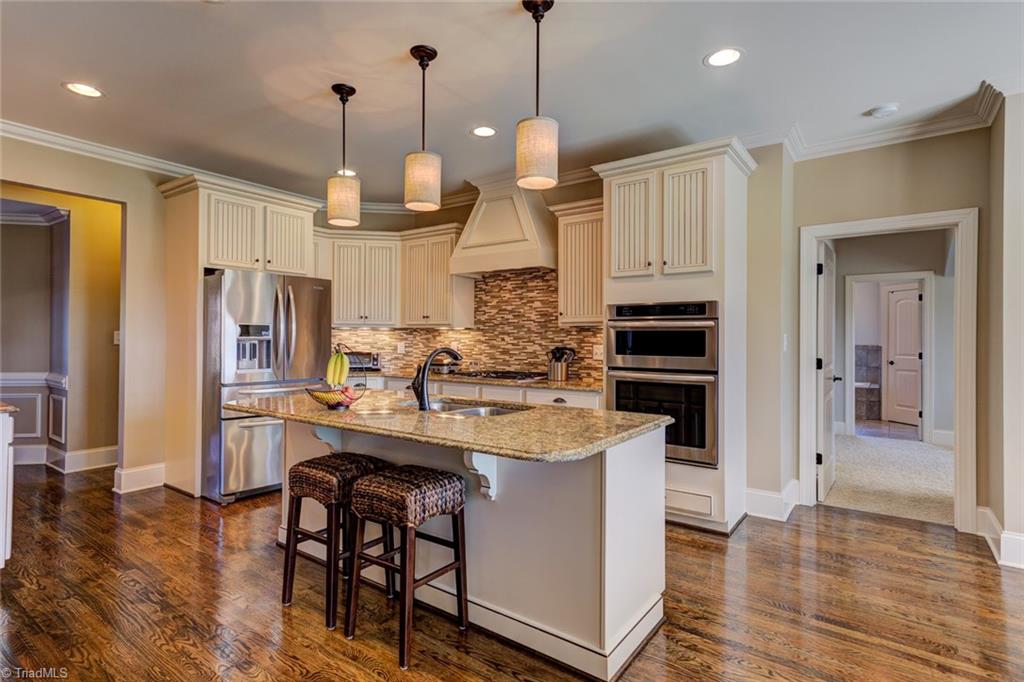 8889 Rymack Drive Oak Ridge, NC 27310 - Photo 8 of 30 A gourmet kitchen includes the kitchen island with breakfast bar seating.