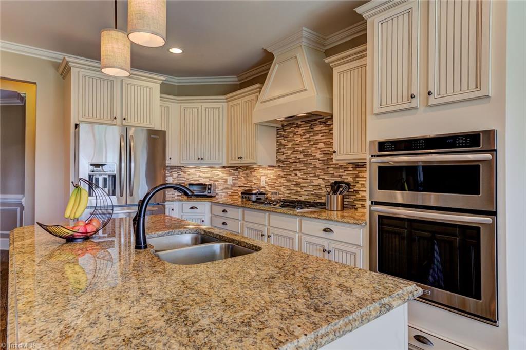 8889 Rymack Drive Oak Ridge, NC 27310 - Photo 9 of 30 High quality granite countertops and tile backsplash. Stainless steel appliances include built-in oven, convection oven, gas cook top, dishwasher.