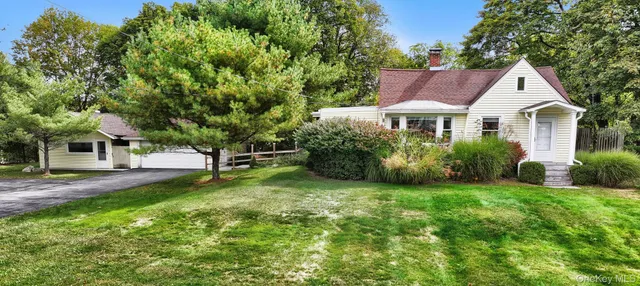 a front view of a house with a yard and trees