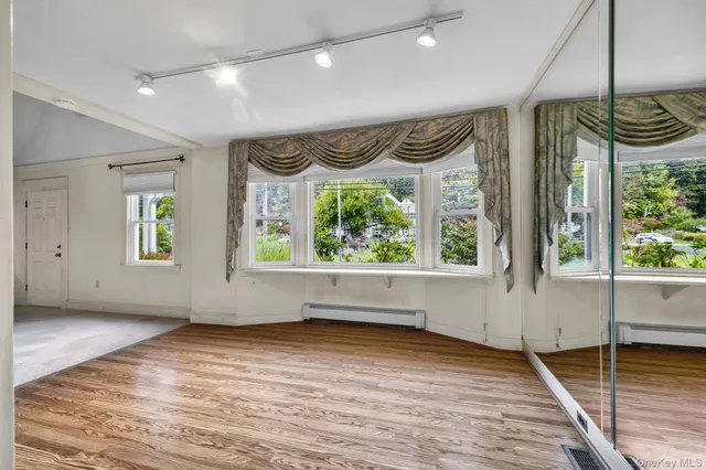 a view of an empty room with window wooden floor and windows