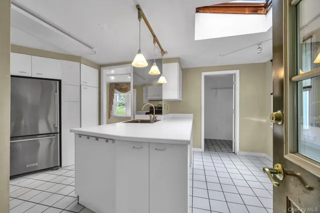 a kitchen with kitchen island a sink appliances and cabinets