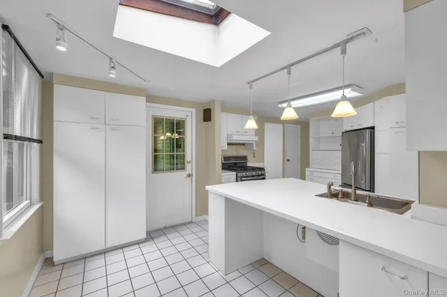 a view of a kitchen with a sink and a refrigerator